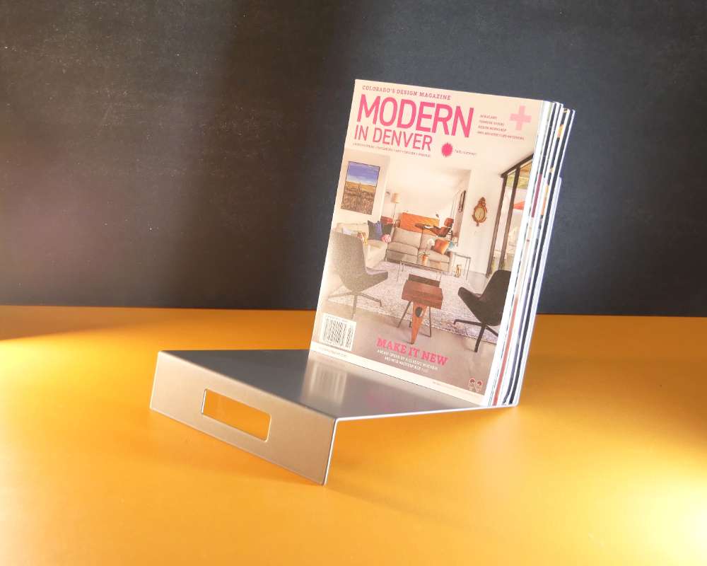a modern silver color metal stand holding magazines