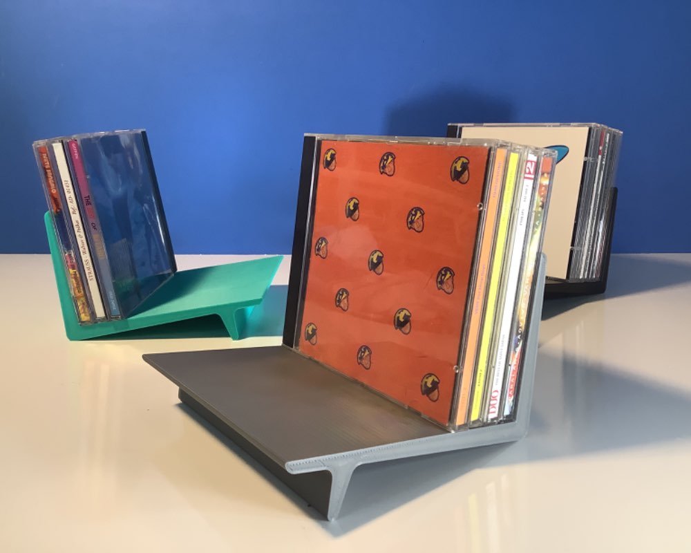 Small leaning stands in turquoise, grey and black for holding up to twelve compact disk cases
