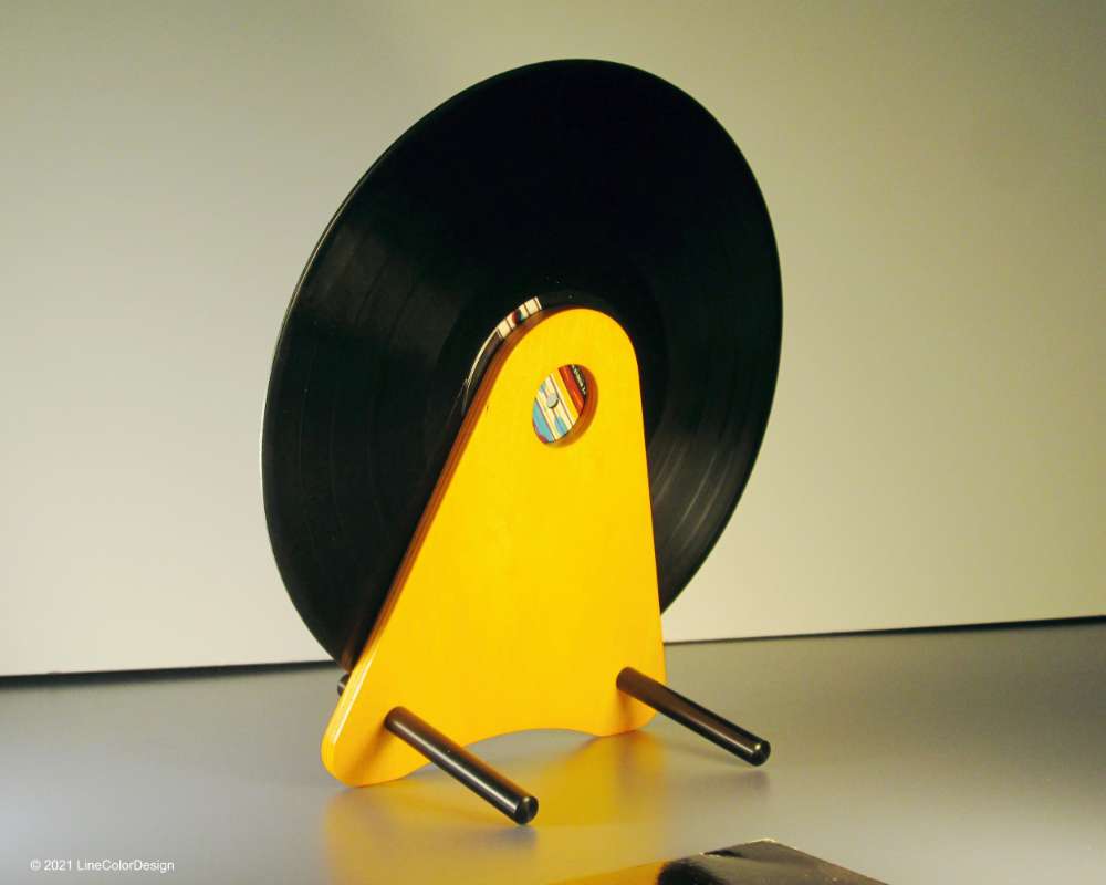 orange triangular wood stand holding a black vinyl record disk at an angle