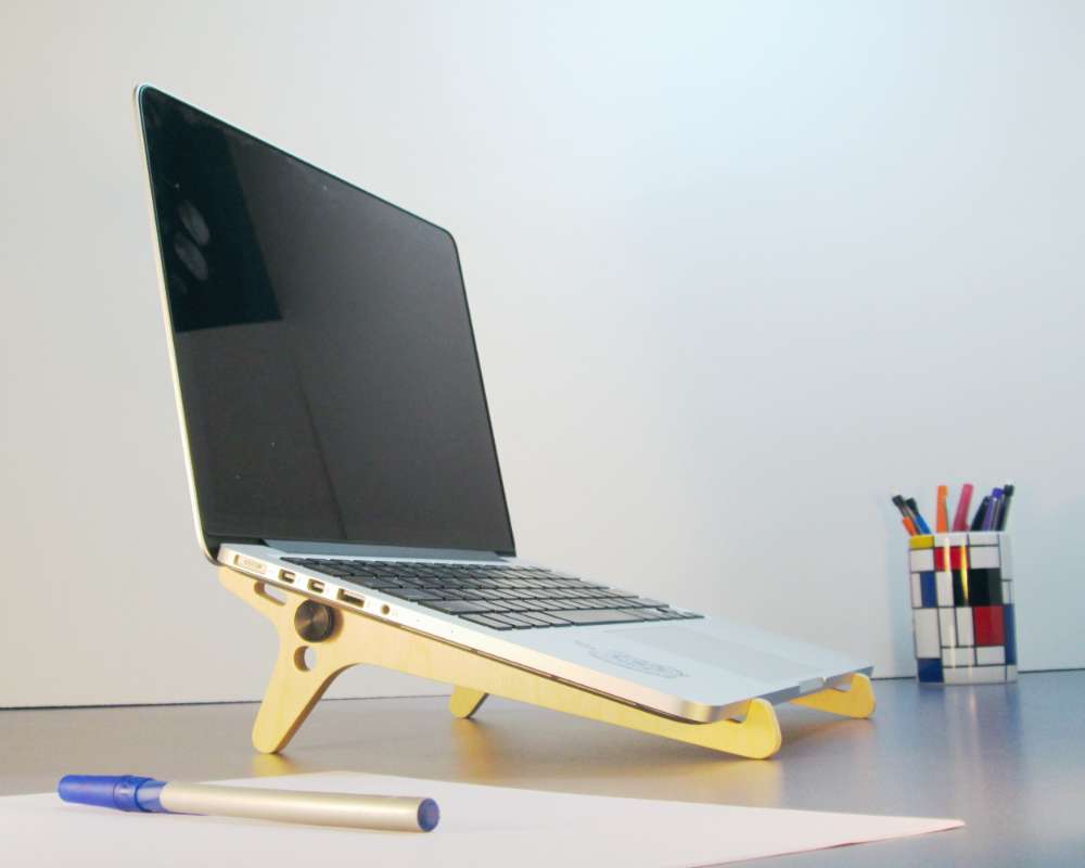 a wood stand holding a laptop computer at a slight angle